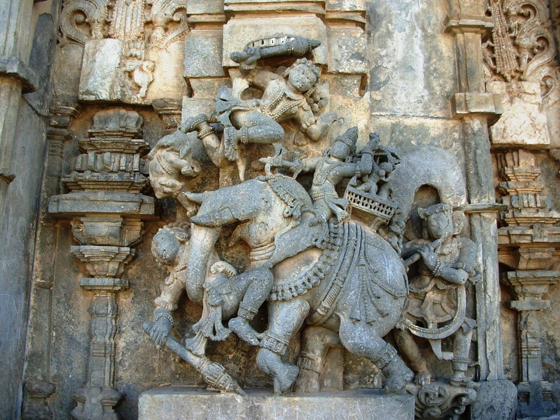 कर्नाटक के बेलूर में चेन्नकेशव मंदिर की दीवार पर युद्ध का दृश्य, जिसमें साज़ से सजा हाथी और उस पर सवार योद्धा हैं; कोश जिस चार अंगों वाली सेना की बात करते हैं, हाथी उसका एक अंग है
