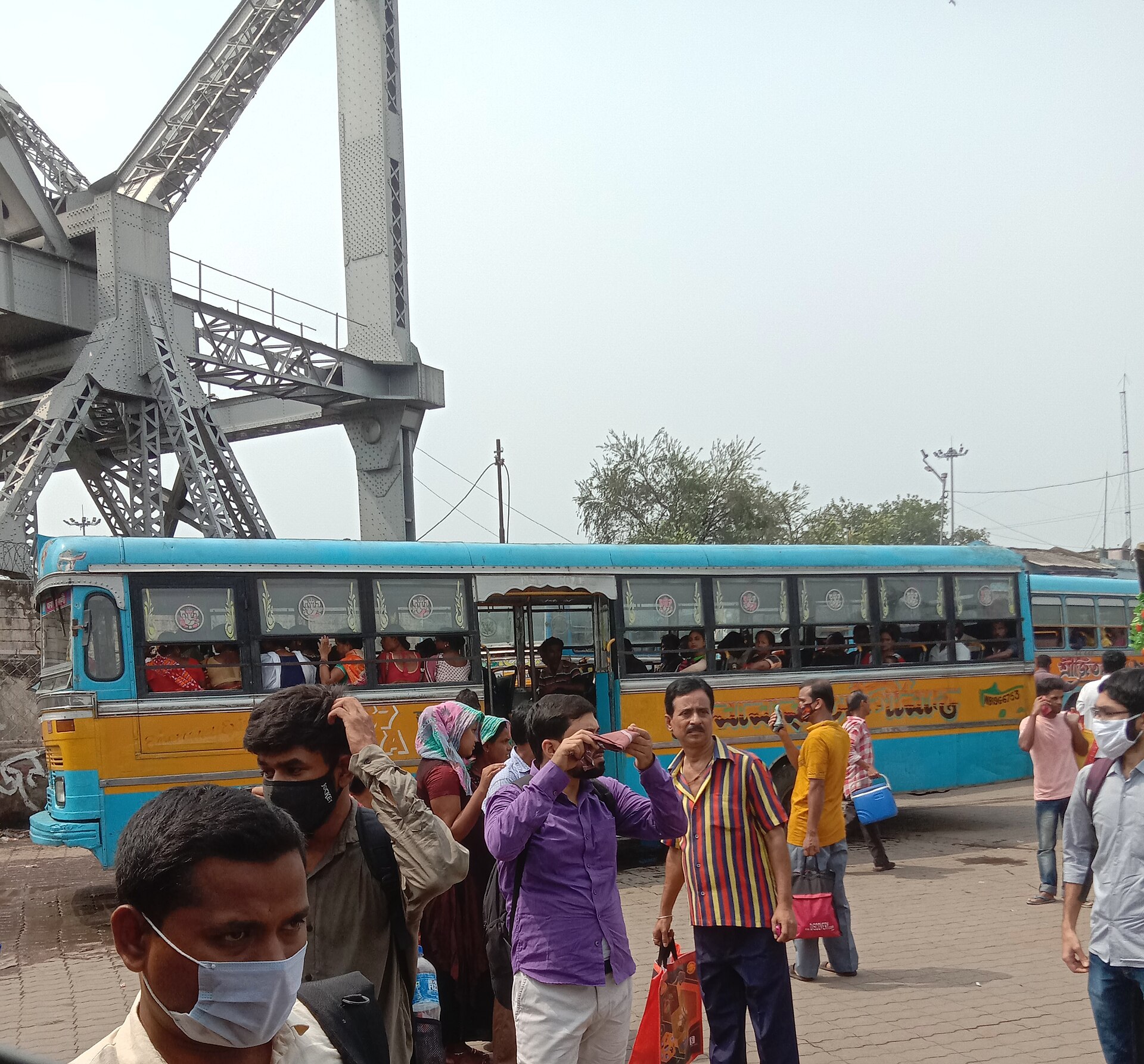 हावड़ा बस स्टैंड पर बसें और यात्री, मई 2022 की तस्वीर; रोज़मर्रा की यात्रा में बस का यही दबदबा सर्वेक्षण के आँकड़ों में भी दिखता है