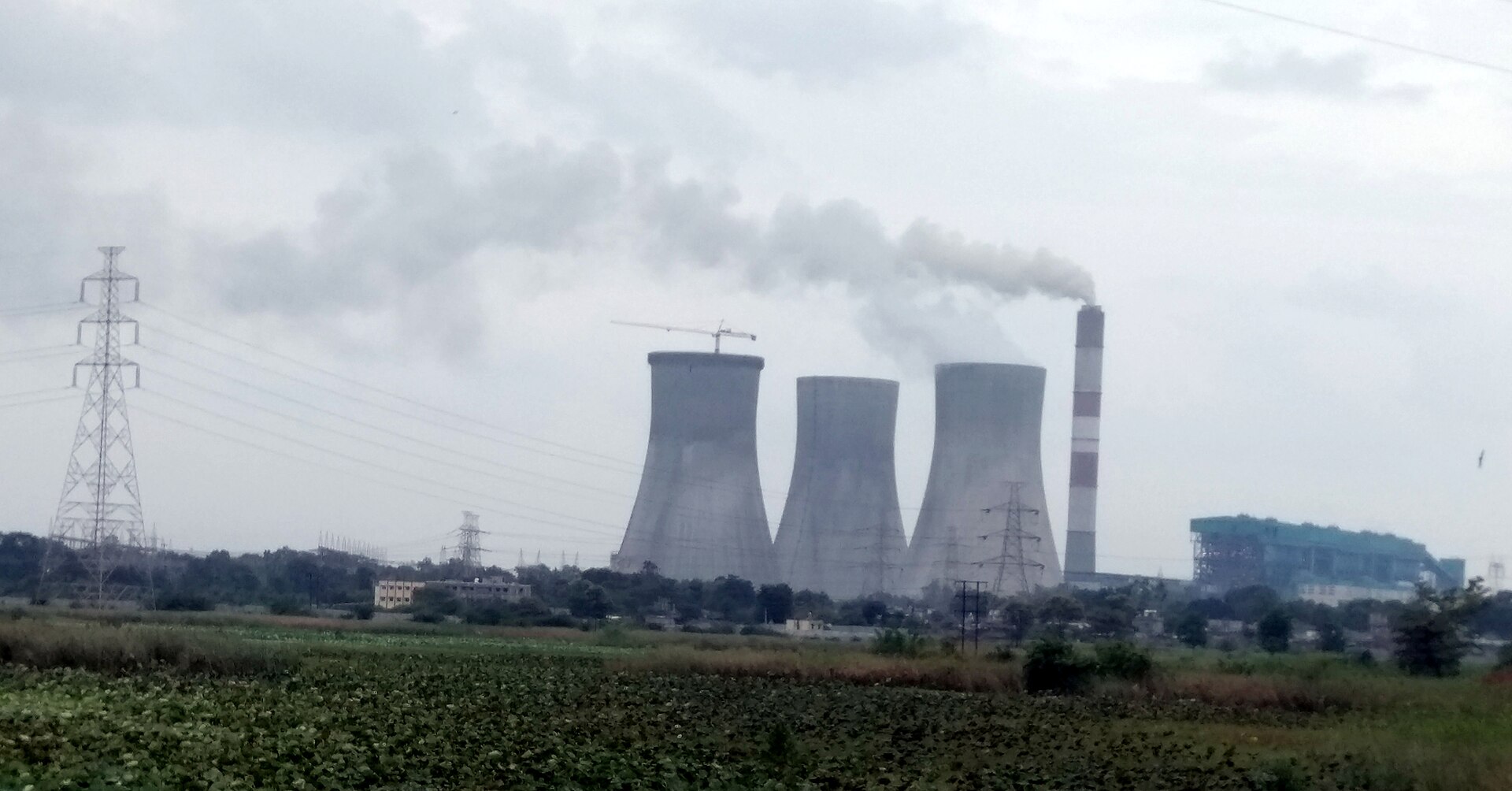 महाराष्ट्र के कोराडी ताप बिजलीघर का कूलिंग टैंक और चिमनी, हाईवे से ली गई तस्वीर, अगस्त 2016; ऐसे ही बिजलीघरों के कोयला भंडार की रोज़ की रिपोर्ट केंद्रीय विद्युत प्राधिकरण बनाता है
