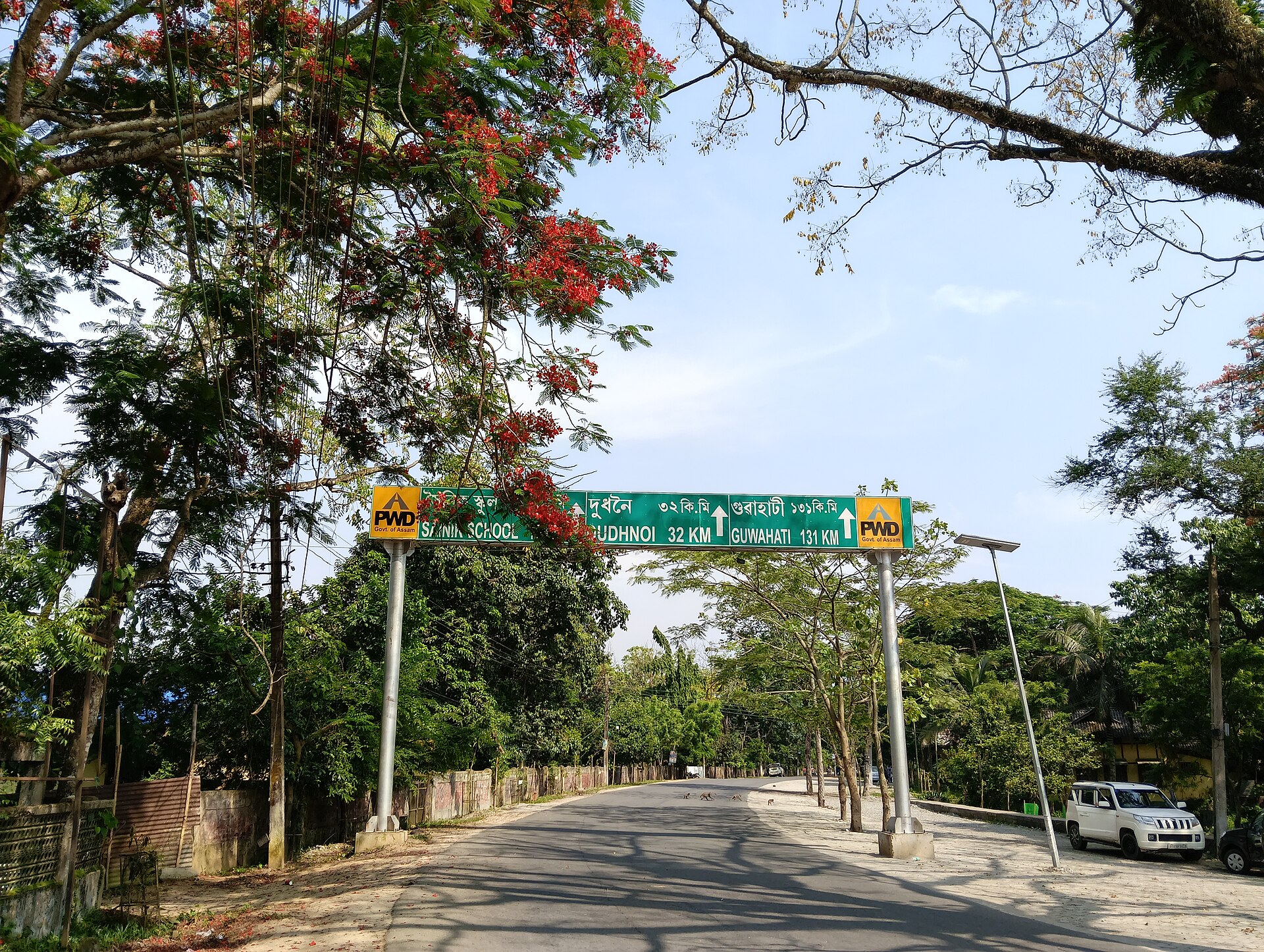 गोलपाड़ा ज़िले के मटिया में सड़क पर लगा असम लोक निर्माण विभाग का दिशा-सूचक, जून 2026 की तस्वीर; 5 सितंबर के नोटिस इसी मटिया राजस्व सर्कल के अंचल अधिकारी के दफ़्तर से निकले थे