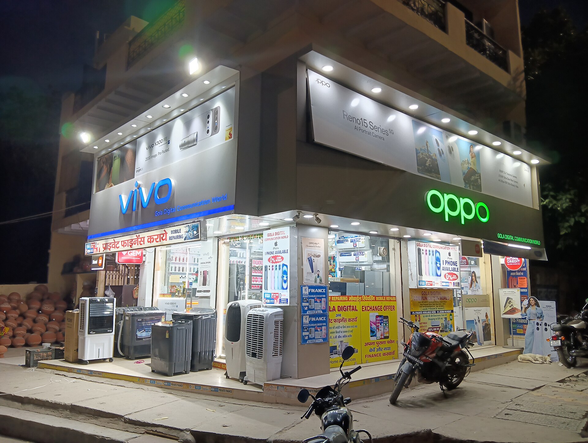 दिल्ली के दाबड़ी इलाक़े में एक मोबाइल फ़ोन की दुकान, जून 2026 की तस्वीर; नए वॉइस-एसएमएस वाउचर की क़ीमत आख़िरकार ऐसी ही दुकानों और ऐप पर दिखेगी